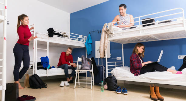 istock Young men and women friendly interacting while staying in modern comfy hostel 1067038072