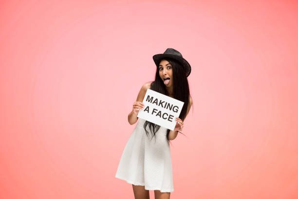 istock Beautiful female on pink background is making a silly face 1067038274