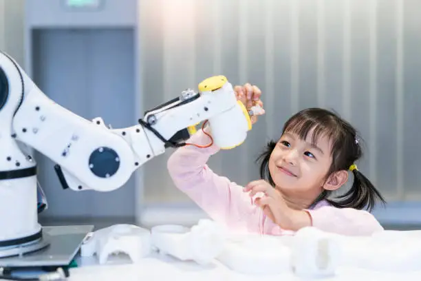 Photo of little Girl Building Robotic Arm At School