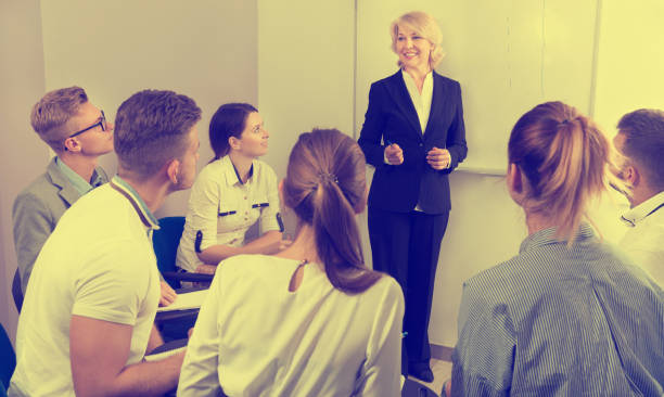 istock Female teacher lecturing to students at auditorium 1067040246
