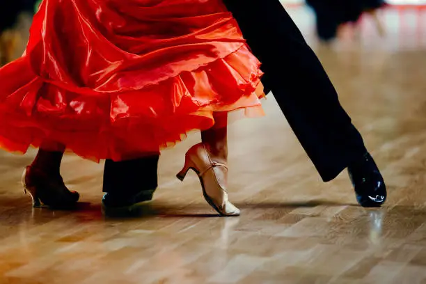 Photo of dance sports couple red dress black suit tail