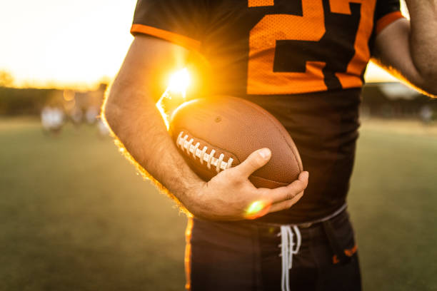 american football player holding ball - football player american football sport determination imagens e fotografias de stock