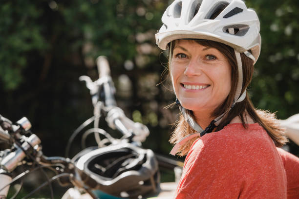 retrato de uma mulher madura - capacete de ciclismo - fotografias e filmes do acervo