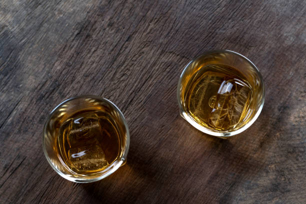 istock Whiskey with ice in glass on wooden table 1067063914
