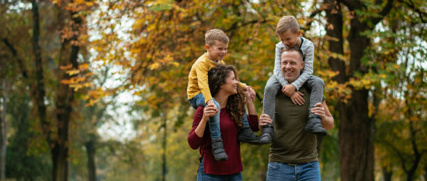 familie spaß im park - family four people smiling autumn stock-fotos und bilder