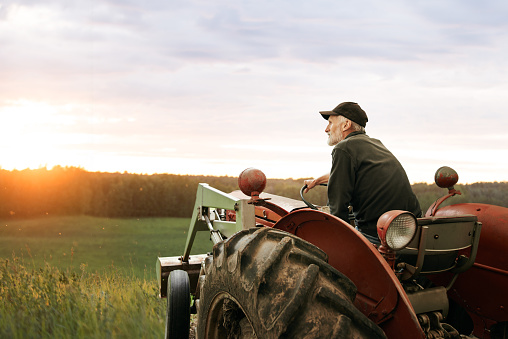 Shot of a man operating a tractor on a farm