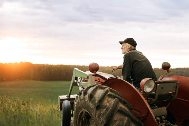What’s a farmer without his tractor? Shot of a man operating a tractor on a farm Farmer stock pictures, royalty-free photos & images