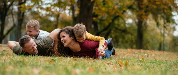 familie spaß im park - family four people smiling autumn stock-fotos und bilder