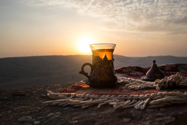 istock Arabian tea in glass on a eastern carpet. Eastern tea concept. Armudu traditional cup. Sunset background. Selective focus 1067072258