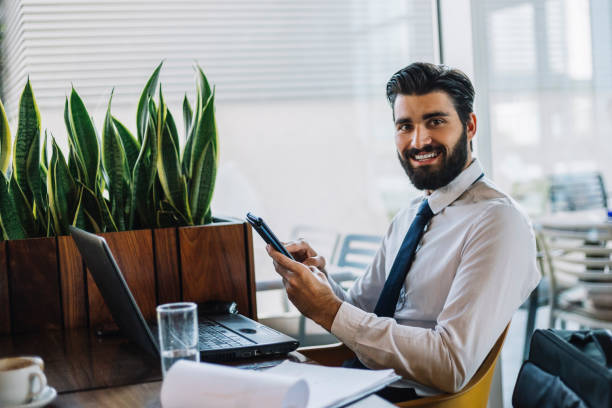 istock Attractive young businessman drinks coffee and using smart phone 1067079288