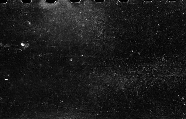 Old Scratched Film Strip Grunge Texture Background A close-up scan of an old scratched 35mm film strip grunge texture background. film reel stock pictures, royalty-free photos & images