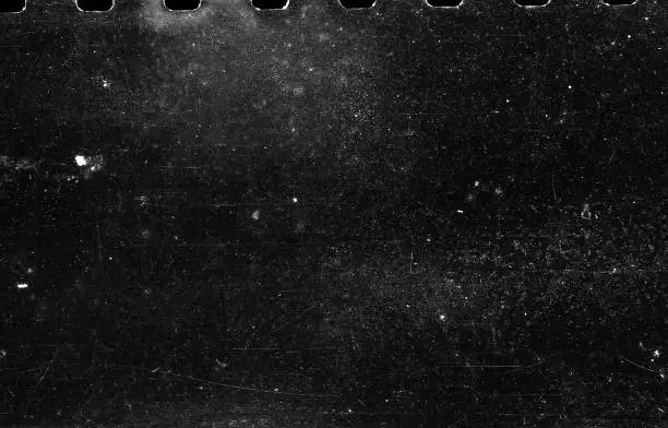 A close-up scan of an old scratched 35mm film strip grunge texture background.
