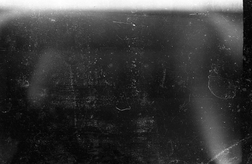 A close-up scan of an old scratched 35mm film strip grunge texture background.