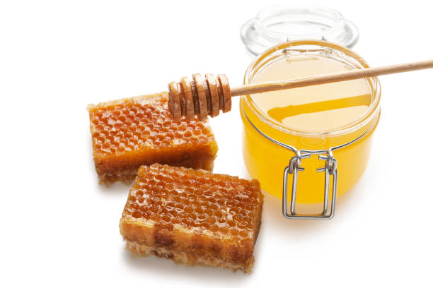 istock Jar full of fresh honey and honeycombs isolated on white 1067110322