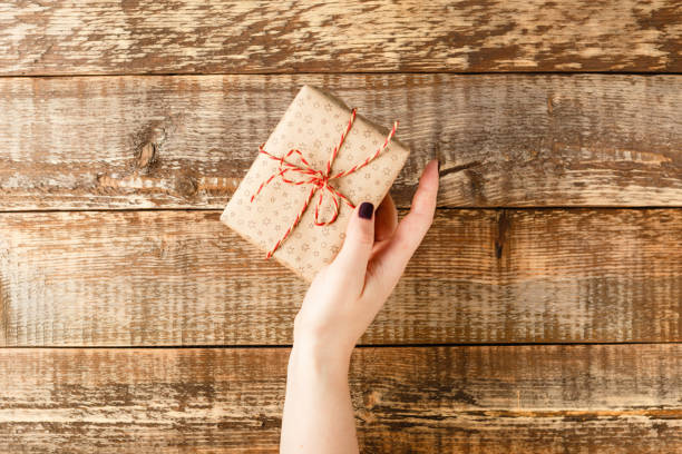 istock Hands holding craft paper gift box 1067114234