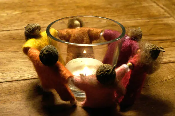 Photo of dancing handicrafted work dolls around candle