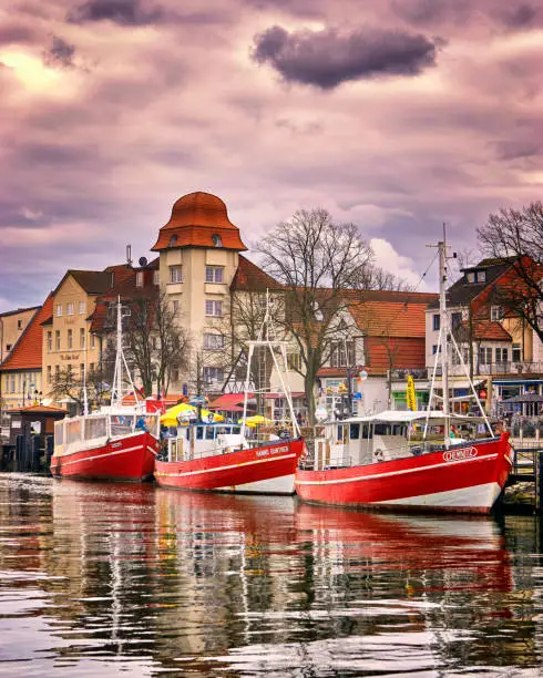Three fishing boats in Warnemünde at the old canal or old creek. The once sleepy fishing village was founded in 1200.