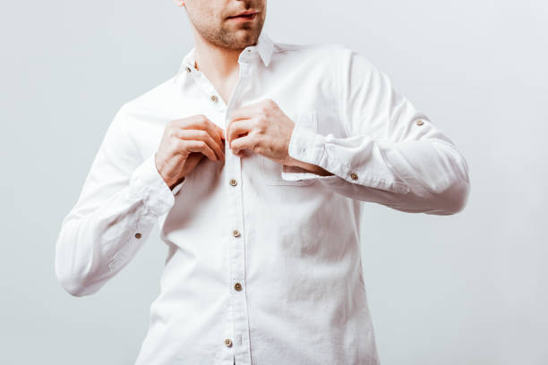 istock partial view of businessman buttoning up white shirt isolated on grey 1067117512