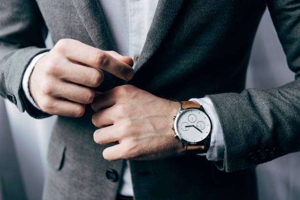 istock partial view of businessman with watch buttoning up jacket 1067118814