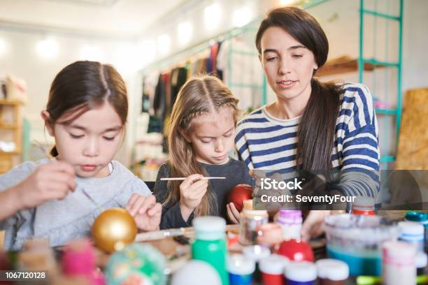 Foto de Crianças Pintando Enfeites De Natal Artesanal e mais fotos de stock de Bola de Árvore de Natal - Bola de Árvore de Natal, Criança, Pintar