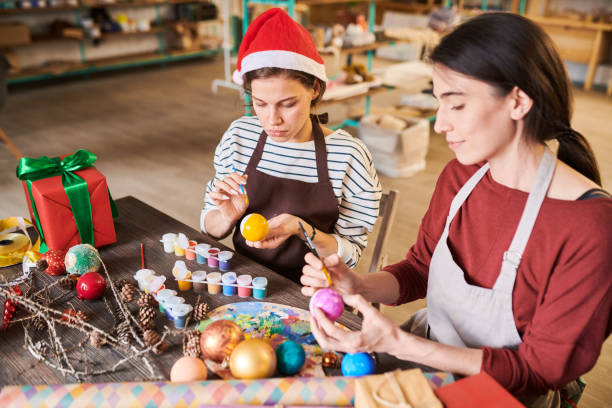 istock Two Women Painting Christmas Decorations 1067120322