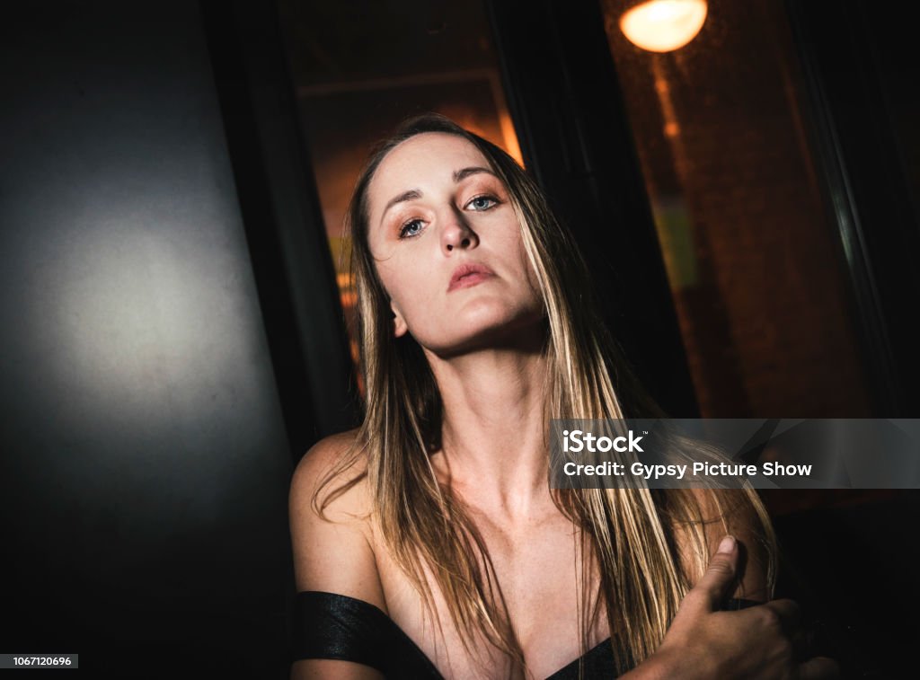 beautiful female model posing in a cocktail dress with moody lighting Cocktail Dress Stock Photo