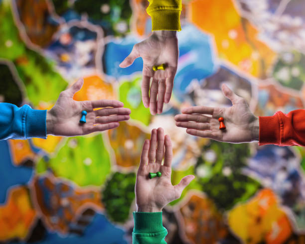 Board game concept- choose yours figures. People holding in hand colorful playing figures on blurred board game field background.
