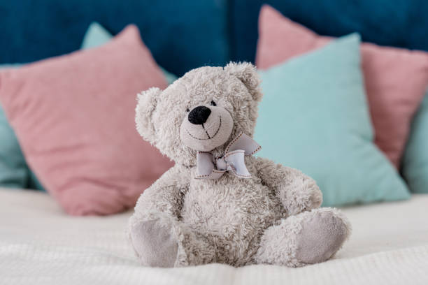 istock Close up horizontal view of teddy bear sitting on the bed with pillows on background 1067123100