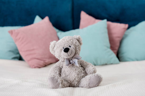istock teddy bear sitting on the bed with pillows on background 1067123142