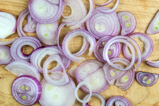 istock Sliced red onion rings on wooden background top view 1067126504