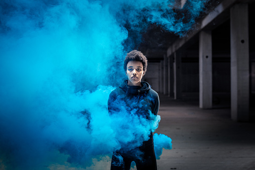 Portrait of a Young Woman With a Blue Smoke Bomb