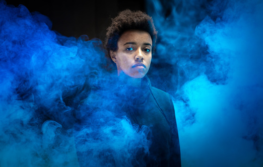 Portrait of a Young Woman With a Blue Smoke Bomb