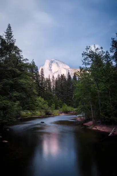 Half Dome and the Merced River, in California's Yosemite National park as a thunderstorm rolls in. Long exposure