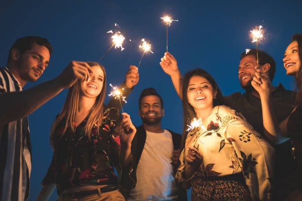 istock Friends enjoying rooftop party with sparklers 1067130318