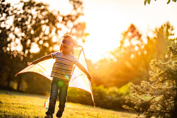 Playful little girl playing whit kite in nature