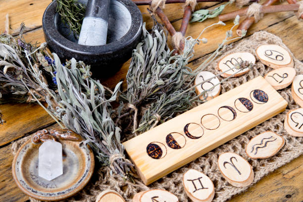 Moon Phases and astrological symbols with herb witch mortar and pestle Moon Phases and astrological symbols with herb witch mortar and pestle, with branch pentagram and dried herb bundles crystal altar stock pictures, royalty-free photos & images