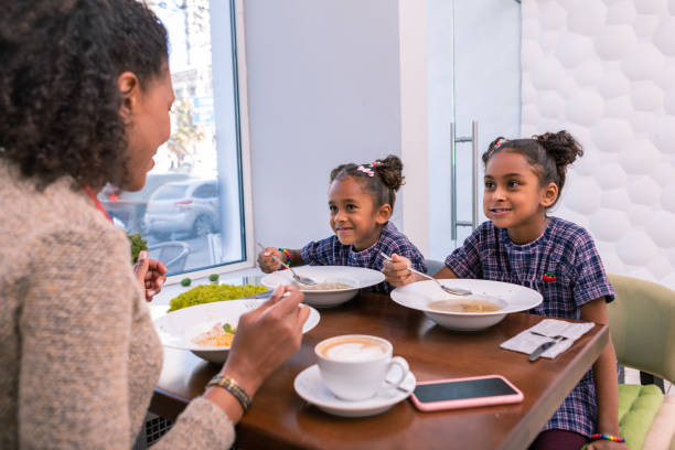 istock Mother and two daughters eating soup in restaurant on weekend 1067137146