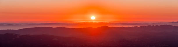 puesta de sol rojo sobre un mar de nubes - hill dusk sunset heat haze fotografías e imágenes de stock