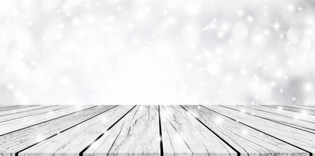 istock abstract blurred white and silver color backdrop with snow falling effect and  vintage white wood tabletop for show and promote products on display 1067147902