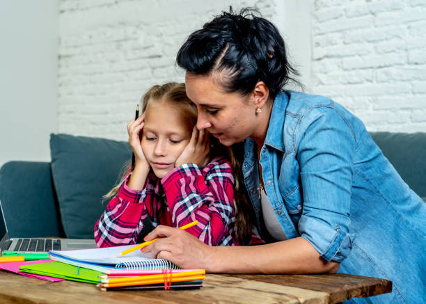 istock Patience mum with daughter unable to concentrate whilst doing homework sitting on sofa at home in learning difficulties homework parenting and education concept 1067153772