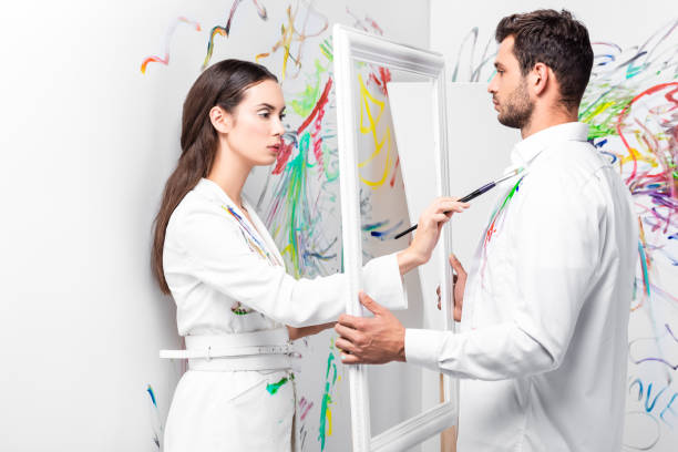 istock attractive adult woman drawing on clothes while man holding frame 1067155676