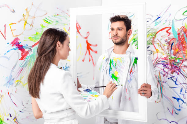 istock attractive adult woman drawing on clothes while man holding frame 1067155694