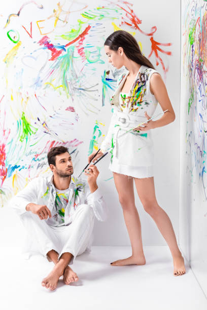 istock couple in painted white clothes with drawing equipment 1067155846