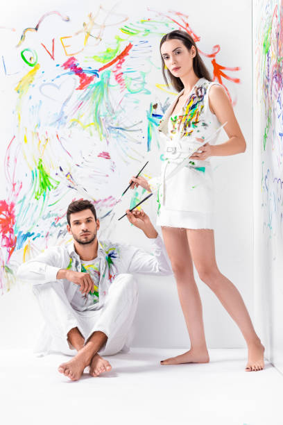 istock barefoot couple in painted white clothes with drawing equipment 1067155868