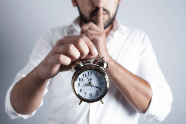 istock businessman holds an alarm clock 1067160236