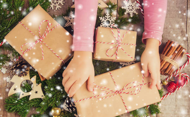 istock Child holds a Christmas decor and gifts on a white background. Selective focus. 1067161808