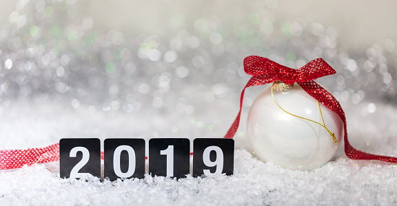 Christmas ball and new year 2019, on snow, abstract bokeh lights background, copy space