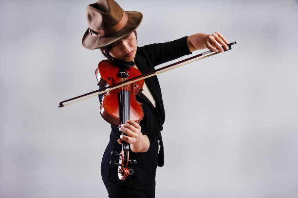Cute female playing the violin while jumping