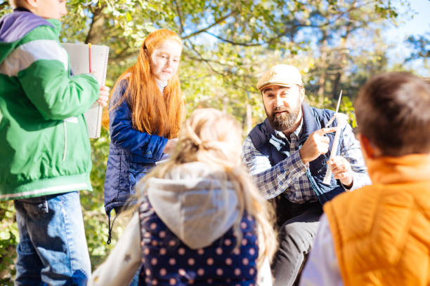 istock Pleasant male teacher pointing at the windmill model 1067174314