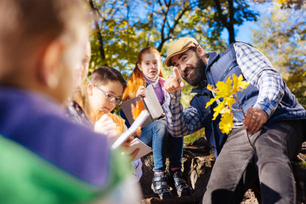 istock Delighted positive teacher being with his pupils 1067174682